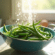 Haricots verts frais lavés dans une passoire en cuisine lumineuse
