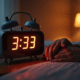 Réveil digital dans la chambre avec mains entrelacees